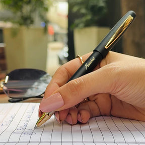 Hand holding a metal pen personalised with a name