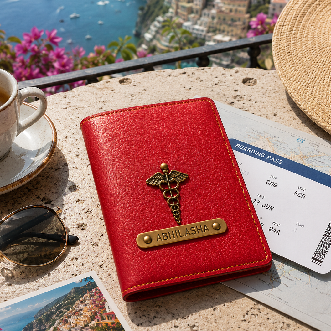 Red passport holder with a gold emblem on a ledge overlooking a scenic coastal view.