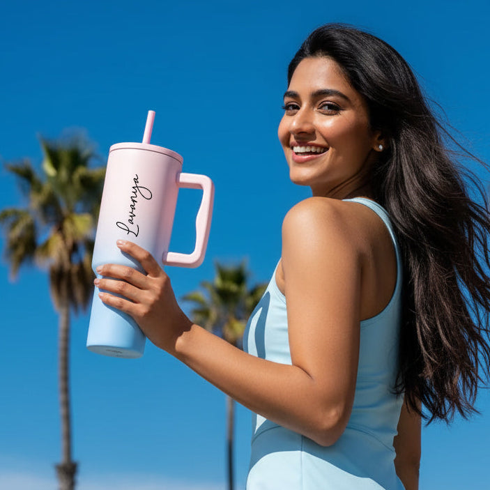 Woman holding a pink tumbler with palm trees and blue sky in the background