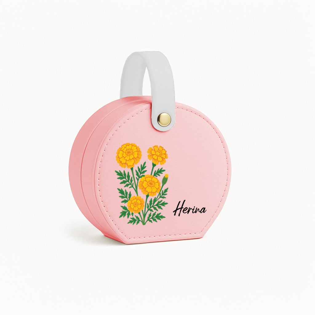 A compact pink travel jewelry box with floral designs
