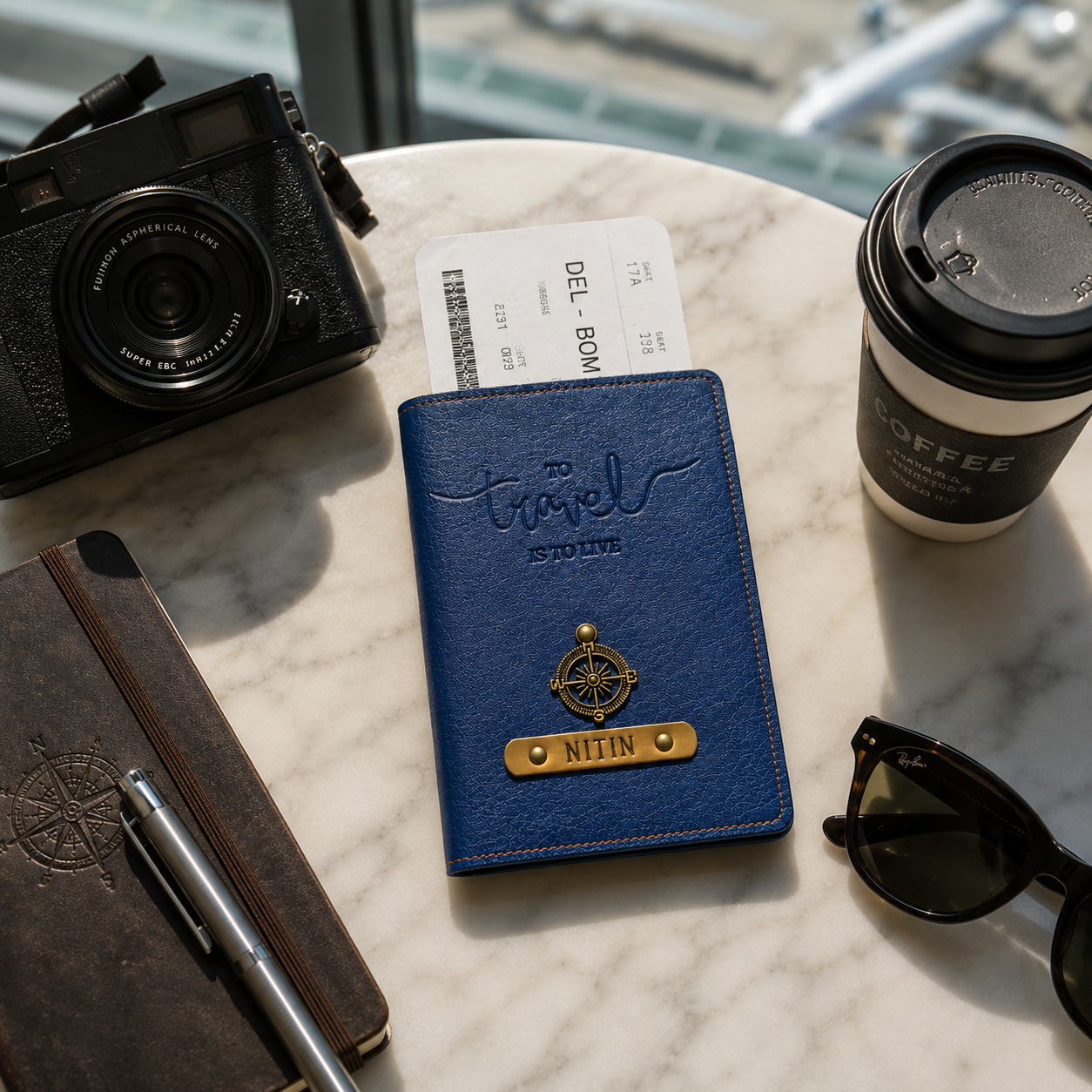 Blue travel wallet with passport and sunglasses on a marble surface