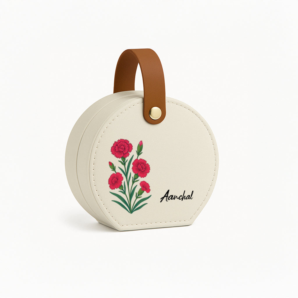 A round white Stella Zip travel jewellery box with a floral design and a brown leather handle.